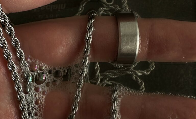 afbeelding van handen die sieraden schoonmaken in water.