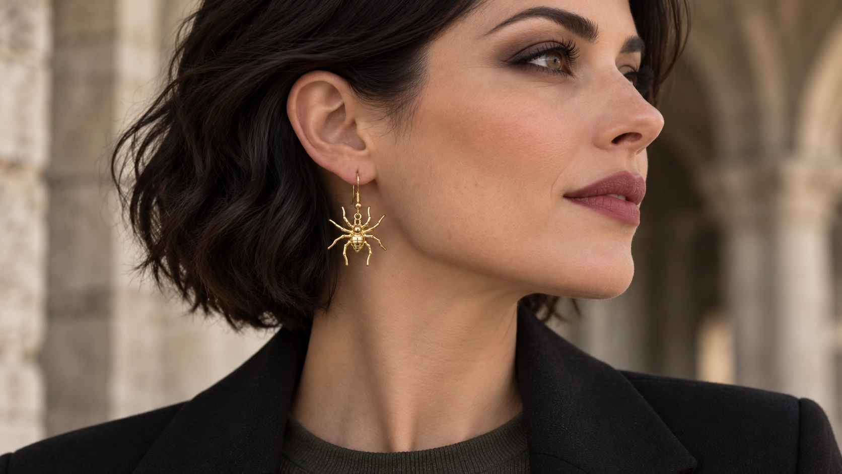 Model met een kleine gouden spinoorbel en subtiele gothic make-up.